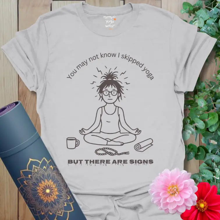 Ice Grey Signs T-Shirt featuring minimalist yogi illustration, messy hair, coffee cup, and mala beads. Relaxed and witty yoga-inspired tee.
