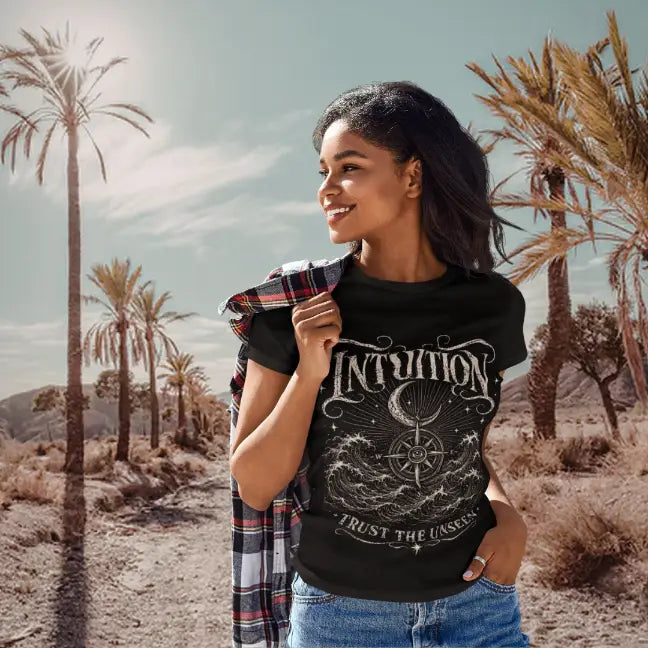 Woman wearing Black Intuition T-Shirt with vintage engraved intuition artwork featuring ocean waves, compass symbolism, and celestial spiritual detailing outdoors.