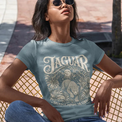 Person wearing the Jaguar T-Shirt in Stone Blue, seated outdoors against a lattice wall — Wild Animals collection by Ramro Yoga Wear.