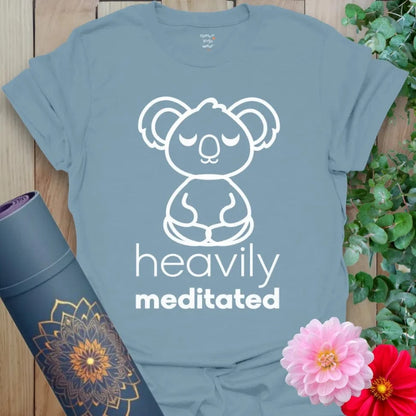 Muted stone blue yoga t-shirt with adorable meditating koala artwork and playful "Heavily Meditated" message.