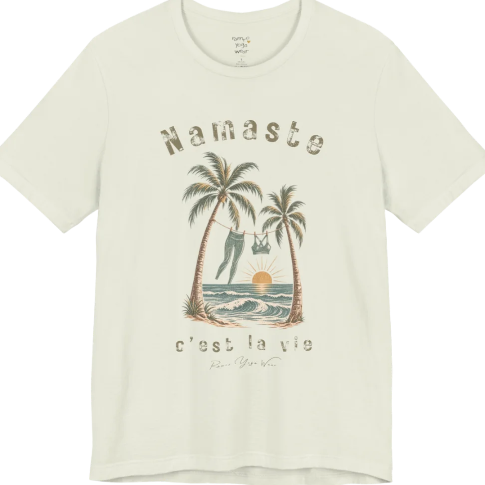 A short sleeved grunge tee with an illustrated scene of two palm trees framing a clothesline with leggings and a sports bra hanging between them, sun setting over waves, text reading "Namaste" and "c'est la vie" — Funny Yoga Shirts collection by Ramro Yoga Wear in Citron.