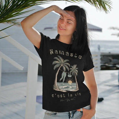 Person wearing the La Vie T-Shirt in Black, standing outdoors on a wooden deck near palm fronds — Funny Yoga Shirts collection by Ramro Yoga Wear.