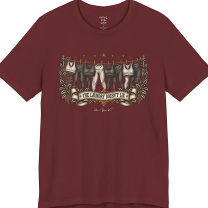 A short sleeved tee. Illustrated clothesline strung with repeating pairs of leggings and tops, framed by botanical leaf sprigs and stars. Laundry T-Shirt flat lay is a Bella+Canvas 3001 and the color is Heather Cardinal.