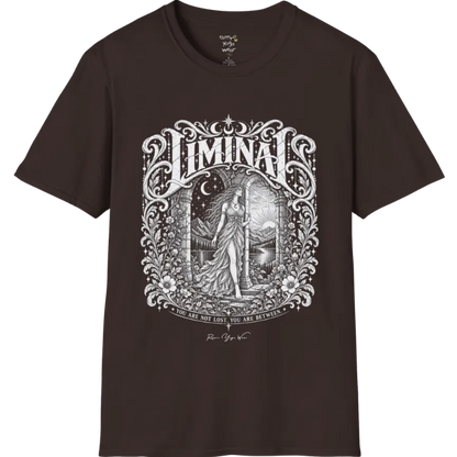 A short sleeved tee called the Liminal T-Shirt, flat lay and a soft cotton shirt. Simply says, 'You are not lost. You are between.' Design highlights ornate white LIMINAL lettering framed by flourishes and wild florals, with a robed figure standing in an arched doorway beneath a crescent moon and stars. Color is Dark Chocolate.