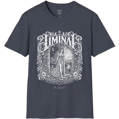 A short sleeved tee called the Liminal T-Shirt, flat lay and a soft cotton shirt. Simply says, 'You are not lost. You are between.' Design highlights ornate white LIMINAL lettering framed by flourishes and wild florals, with a robed figure standing in an arched doorway beneath a crescent moon and stars. Color is Heather Navy.