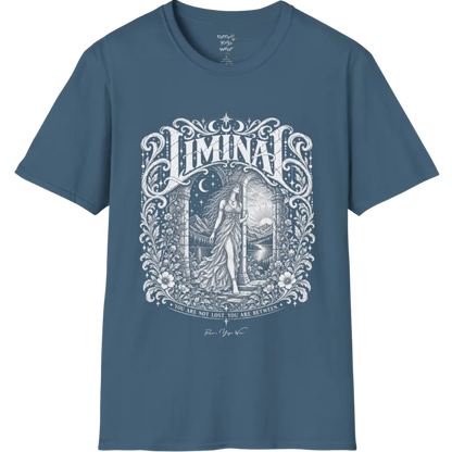 A short sleeved tee called the Liminal T-Shirt, flat lay and a soft cotton shirt. Simply says, 'You are not lost. You are between.' Design highlights ornate white LIMINAL lettering framed by flourishes and wild florals, with a robed figure standing in an arched doorway beneath a crescent moon and stars. Color is Indigo Blue.