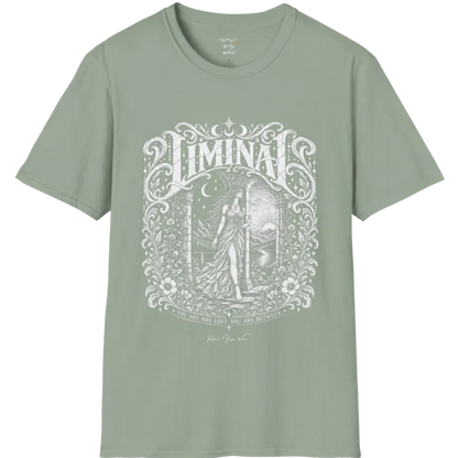 A short sleeved tee called the Liminal T-Shirt, flat lay and a soft cotton shirt. Simply says, 'You are not lost. You are between.' Design highlights ornate white LIMINAL lettering framed by flourishes and wild florals, with a robed figure standing in an arched doorway beneath a crescent moon and stars. Color is Sage.