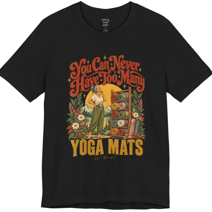 A short sleeved tee called the Mats T-Shirt, flat lay and a soft cotton shirt. Simply says, You Can Never Have Too Many Yoga Mats. Design highlights a silver-haired woman with her hand on her chin, deciding between a wooden rack of rolled yoga mats in rust, mustard, olive, teal and pink, in front of a golden sun, mountains and wildflowers in a retro travel-poster style. Color is Black.