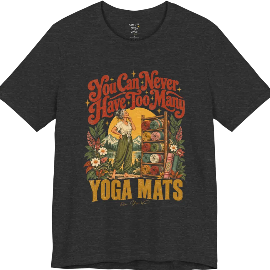 A short sleeved tee called the Mats T-Shirt, flat lay and a soft cotton shirt. Simply says, You Can Never Have Too Many Yoga Mats. Design highlights a silver-haired woman with her hand on her chin, deciding between a wooden rack of rolled yoga mats in rust, mustard, olive, teal and pink, in front of a golden sun, mountains and wildflowers in a retro travel-poster style. Color is Dark Grey Heather.