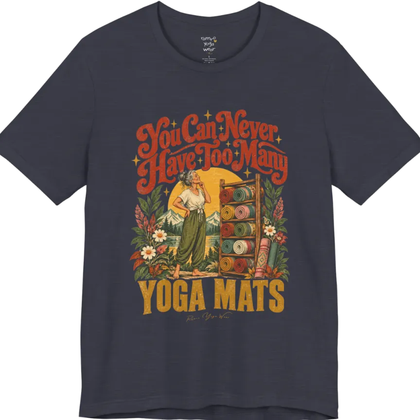 A short sleeved tee called the Mats T-Shirt, flat lay and a soft cotton shirt. Simply says, You Can Never Have Too Many Yoga Mats. Design highlights a silver-haired woman with her hand on her chin, deciding between a wooden rack of rolled yoga mats in rust, mustard, olive, teal and pink, in front of a golden sun, mountains and wildflowers in a retro travel-poster style. Color is Heather Midnight Navy.