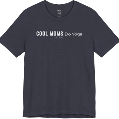 A short sleeved tee called the Moms T-Shirt, flat lay and a soft cotton shirt. Simply says, Cool Moms Do Yoga. Design highlights bold distressed block lettering for Cool Moms beside lighter thin lettering for Do Yoga, with a small script signature underneath. Color is Heather Midnight Navy.