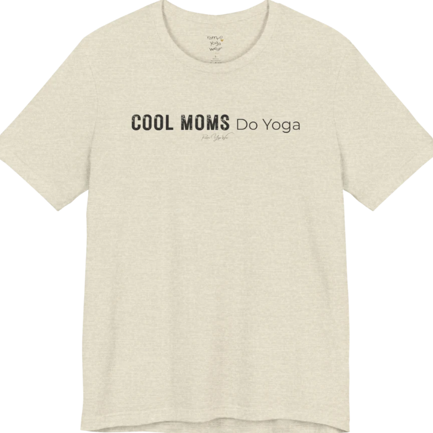 A short sleeved tee called the Moms T-Shirt, flat lay and a soft cotton shirt. Simply says, Cool Moms Do Yoga. Design highlights bold distressed block lettering for Cool Moms beside lighter thin lettering for Do Yoga, with a small script signature underneath. Color is Heather Prism Natural.