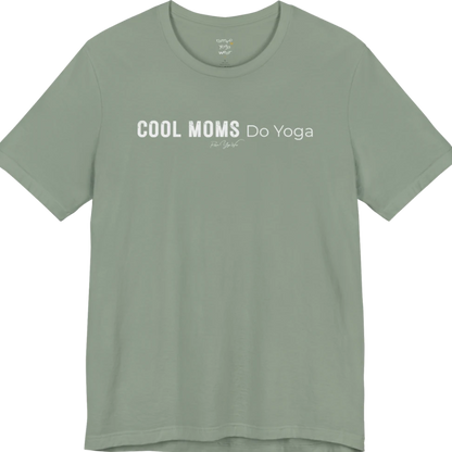 A short sleeved tee called the Moms T-Shirt, flat lay and a soft cotton shirt. Simply says, Cool Moms Do Yoga. Design highlights bold distressed block lettering for Cool Moms beside lighter thin lettering for Do Yoga, with a small script signature underneath. Color is Sage.