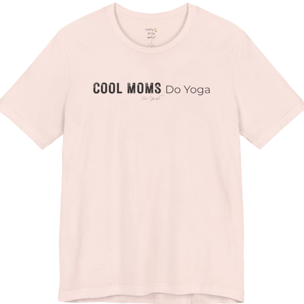 A short sleeved tee called the Moms T-Shirt, flat lay and a soft cotton shirt. Simply says, Cool Moms Do Yoga. Design highlights bold distressed block lettering for Cool Moms beside lighter thin lettering for Do Yoga, with a small script signature underneath. Color is Soft Pink.