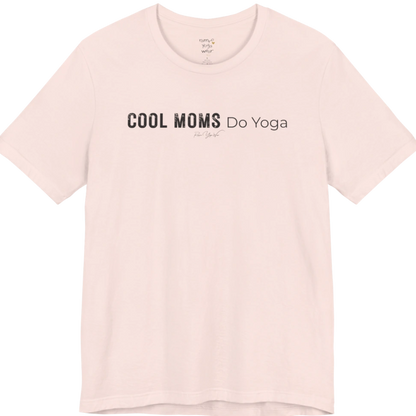 A short sleeved tee called the Moms T-Shirt, flat lay and a soft cotton shirt. Simply says, Cool Moms Do Yoga. Design highlights bold distressed block lettering for Cool Moms beside lighter thin lettering for Do Yoga, with a small script signature underneath. Color is Soft Pink.