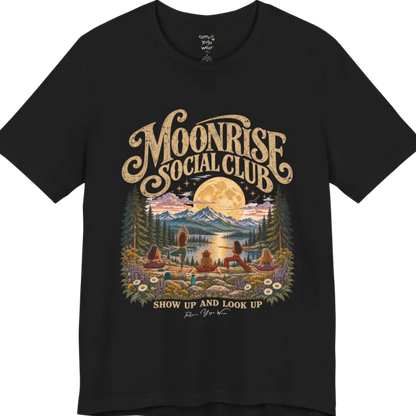 A short sleeved tee called the Moonrise T-Shirt, flat lay and a Bella+Canvas 3001. Simply says, Moonrise Social Club. Show Up And Look Up. Design highlights five women seen from behind practicing yoga on a rocky lakeside shelf, one in tree pose, one in warrior pose and three seated, beneath a glowing full moon rising over snow-capped mountains, framed by pine trees and wildflowers. Color is Black.