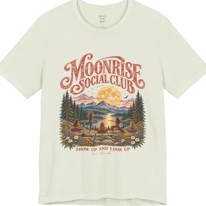 A short sleeved tee called the Moonrise T-Shirt, flat lay and a Bella+Canvas 3001. Simply says, Moonrise Social Club. Show Up And Look Up. Design highlights five women seen from behind practicing yoga on a rocky lakeside shelf, one in tree pose, one in warrior pose and three seated, beneath a glowing full moon rising over snow-capped mountains, framed by pine trees and wildflowers. Color is Citron.