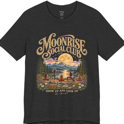 A short sleeved tee called the Moonrise T-Shirt, flat lay and a Bella+Canvas 3001. Simply says, Moonrise Social Club. Show Up And Look Up. Design highlights five women seen from behind practicing yoga on a rocky lakeside shelf, one in tree pose, one in warrior pose and three seated, beneath a glowing full moon rising over snow-capped mountains, framed by pine trees and wildflowers. Color is Dark Heather Grey.