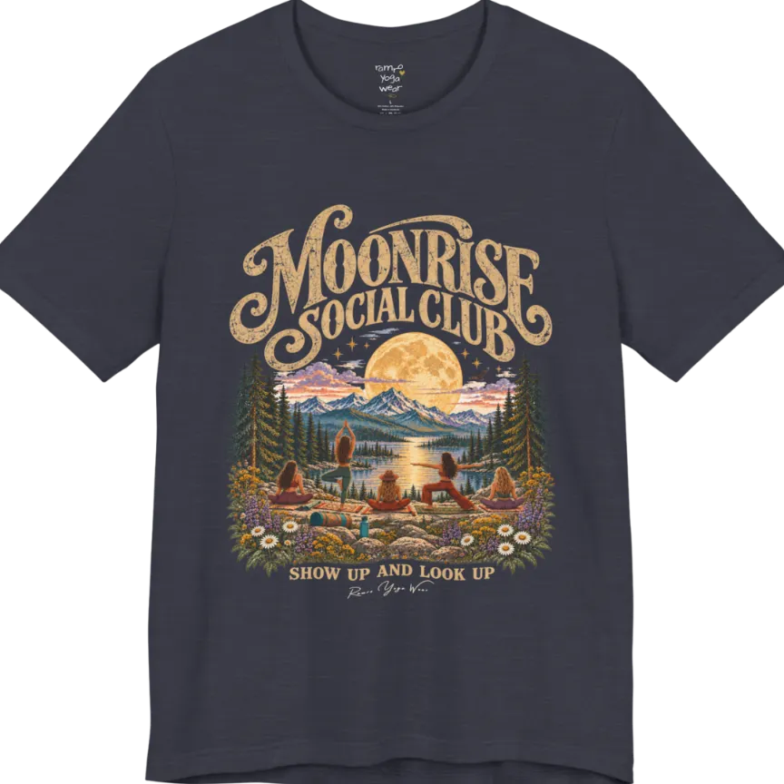 A short sleeved tee called the Moonrise T-Shirt, flat lay and a Bella+Canvas 3001. Simply says, Moonrise Social Club. Show Up And Look Up. Design highlights five women seen from behind practicing yoga on a rocky lakeside shelf, one in tree pose, one in warrior pose and three seated, beneath a glowing full moon rising over snow-capped mountains, framed by pine trees and wildflowers. Color is Heather Midnight Navy.