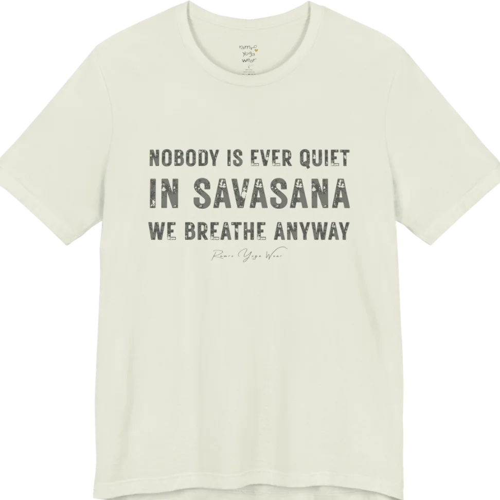 A short sleeved tee called the Nobody T-Shirt, flat lay and a soft cotton shirt. Simply says, Nobody is ever quiet in savasana. We breathe anyway. Design highlights three lines of bold condensed cream lettering with a small handwritten signature beneath. Color is Citron.
