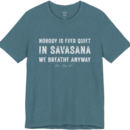 A short sleeved tee called the Nobody T-Shirt, flat lay and a soft cotton shirt. Simply says, Nobody is ever quiet in savasana. We breathe anyway. Design highlights three lines of bold condensed cream lettering with a small handwritten signature beneath. Color is Heather Deep Teal.