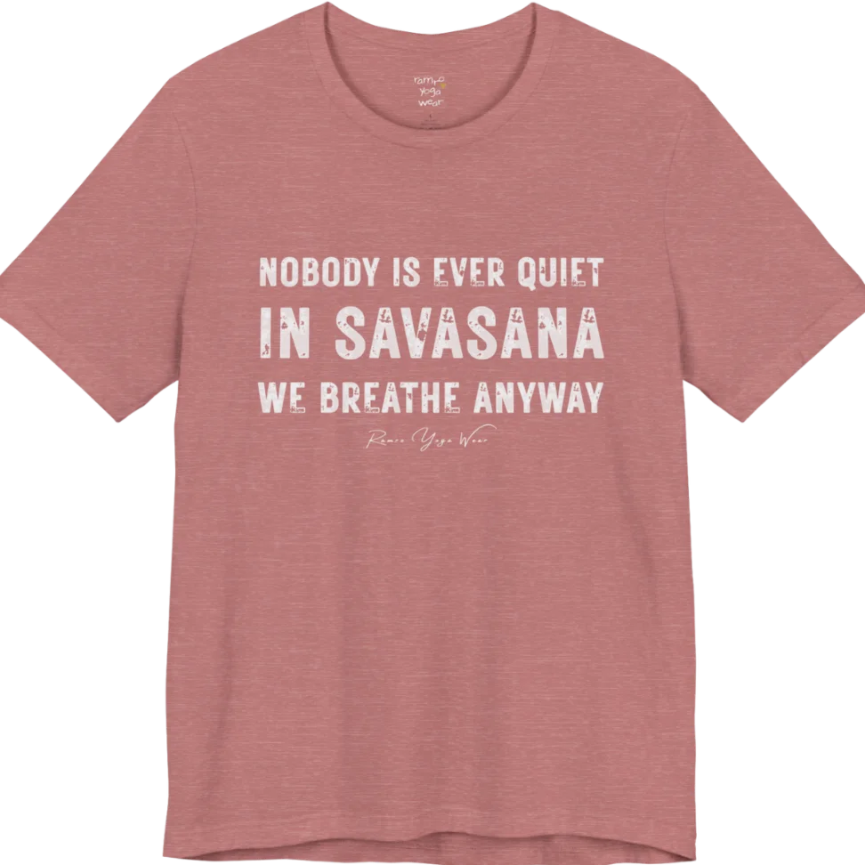 A short sleeved tee called the Nobody T-Shirt, flat lay and a soft cotton shirt. Simply says, Nobody is ever quiet in savasana. We breathe anyway. Design highlights three lines of bold condensed cream lettering with a small handwritten signature beneath. Color is Heather Mauve.