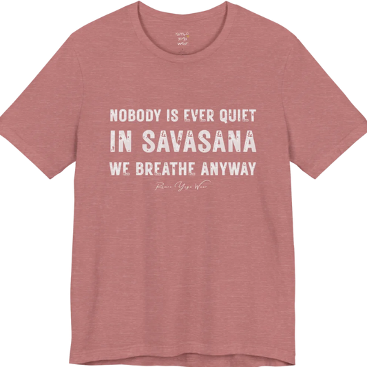 A short sleeved tee called the Nobody T-Shirt, flat lay and a soft cotton shirt. Simply says, Nobody is ever quiet in savasana. We breathe anyway. Design highlights three lines of bold condensed cream lettering with a small handwritten signature beneath. Color is Heather Mauve.