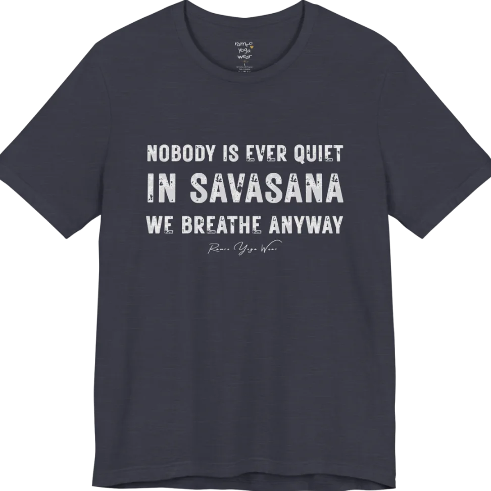 A short sleeved tee called the Nobody T-Shirt, flat lay and a soft cotton shirt. Simply says, Nobody is ever quiet in savasana. We breathe anyway. Design highlights three lines of bold condensed cream lettering with a small handwritten signature beneath. Color is Heather Midnight Navy.