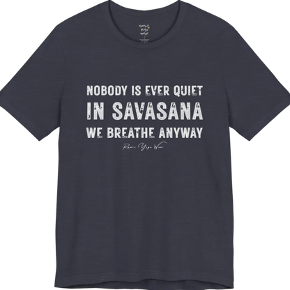 A short sleeved tee called the Nobody T-Shirt, flat lay and a soft cotton shirt. Simply says, Nobody is ever quiet in savasana. We breathe anyway. Design highlights three lines of bold condensed cream lettering with a small handwritten signature beneath. Color is Heather Midnight Navy.