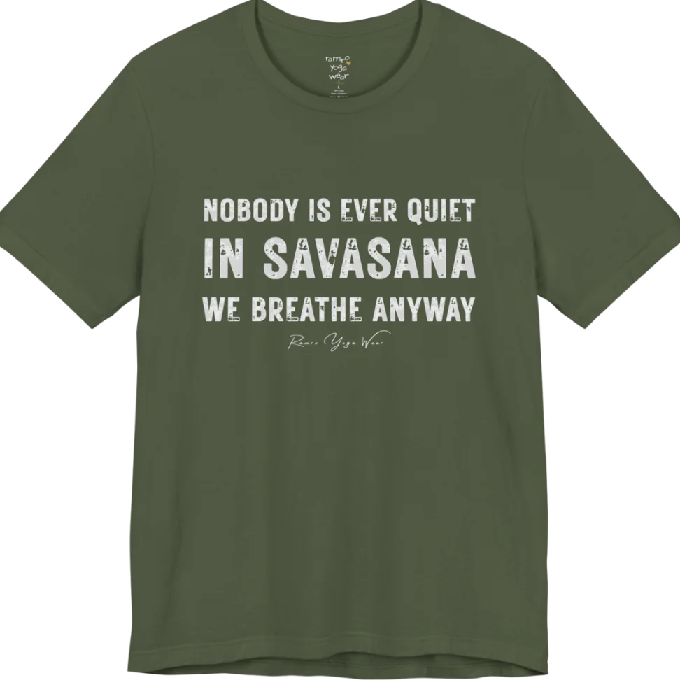 A short sleeved tee called the Nobody T-Shirt, flat lay and a soft cotton shirt. Simply says, Nobody is ever quiet in savasana. We breathe anyway. Design highlights three lines of bold condensed cream lettering with a small handwritten signature beneath. Color is Military Green.