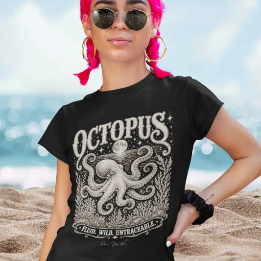Woman wearing Octopus T-Shirt on the beach with pink braided hair, hand on hip, shirt in Black.