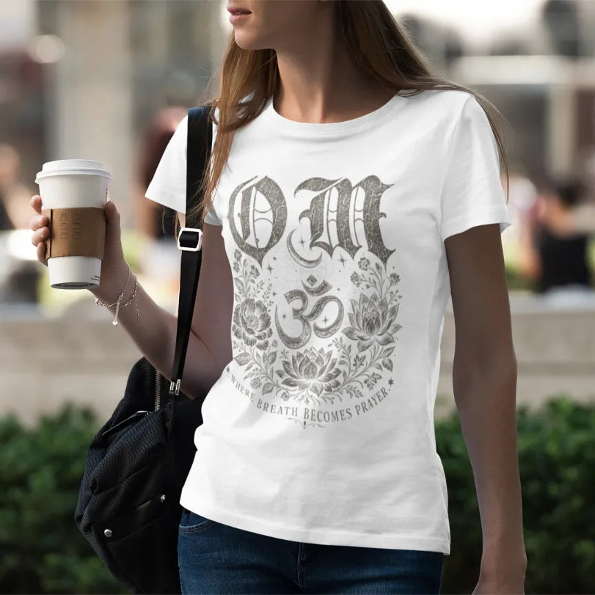 Woman wearing white Om T-Shirt with sacred symbol artwork in calm mindful streetwear-inspired setting.