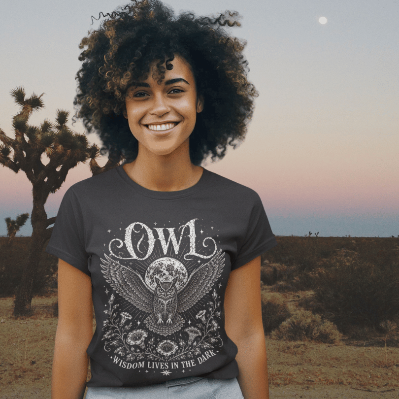 Lifestyle image of model wearing the Owl T-Shirt in a desert setting at sunset featuring mystical owl and moon artwork by Ramro Yoga Wear.