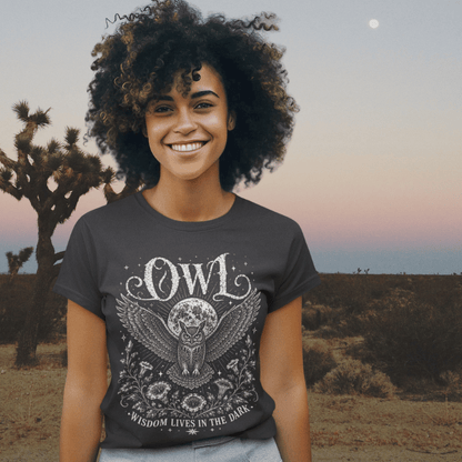 Lifestyle image of model wearing the Owl T-Shirt in a desert setting at sunset featuring mystical owl and moon artwork by Ramro Yoga Wear.