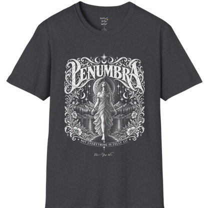 A short sleeved tee called the Penumbra T-Shirt, flat lay and a Gildan 64000 shirt. Simply says, Not Everything Is Fully Lit. Design highlights a moon goddess bathed in radiant light against a mountain backdrop, framed in ornate vintage lettering with botanical detailing. Color is Dark Heather Grey.