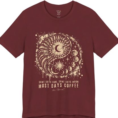A short sleeved tee called the Phases T-Shirt, flat lay and a Bella+Canvas 3001 shirt. Simply says, Some Days Sun, Some Days Moon, Most Days Coffee. Design highlights a grunge yin yang made of a radiating sun and a tail of moon phases, with stars and ink splatter. Color is Heather Cardinal.