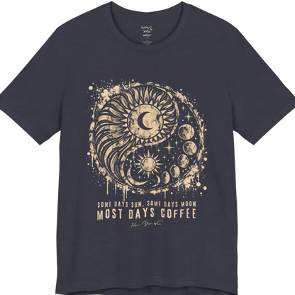 A short sleeved tee called the Phases T-Shirt, flat lay and a Bella+Canvas 3001 shirt. Simply says, Some Days Sun, Some Days Moon, Most Days Coffee. Design highlights a grunge yin yang made of a radiating sun and a tail of moon phases, with stars and ink splatter. Color is Heather Midnight Navy.