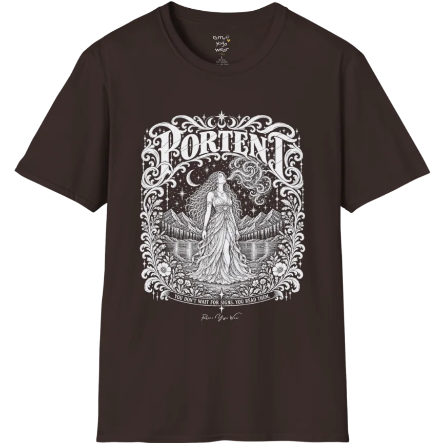 A short sleeved tee called the Portent T-Shirt, flat lay and a soft cotton shirt. Simply says, You don't wait for signs. You read them. Design highlights an ornate engraved frame of florals and filigree around a long-haired figure in a flowing gown standing before mountains and still water, with a crescent moon, stars and swirling smoke above and Portent in decorative lettering across the top. Color is Dark Chocolate.