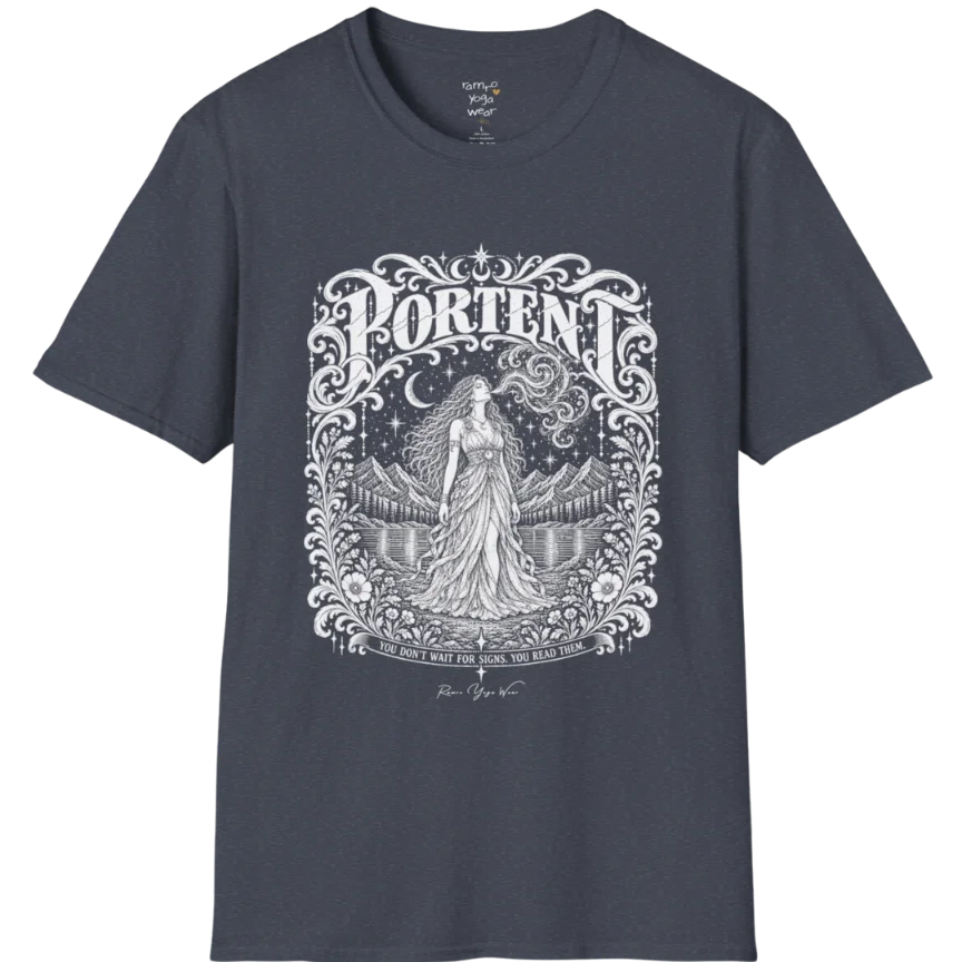 A short sleeved tee called the Portent T-Shirt, flat lay and a soft cotton shirt. Simply says, You don't wait for signs. You read them. Design highlights an ornate engraved frame of florals and filigree around a long-haired figure in a flowing gown standing before mountains and still water, with a crescent moon, stars and swirling smoke above and Portent in decorative lettering across the top. Color is Heather Navy.