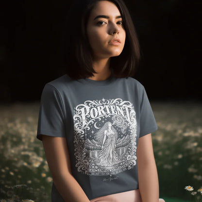 A person with a dark bob haircut and a calm gaze, wearing a blue-grey Portent T-Shirt with a white engraved figure and crescent moon design, sitting in a field of white daisies at dusk.