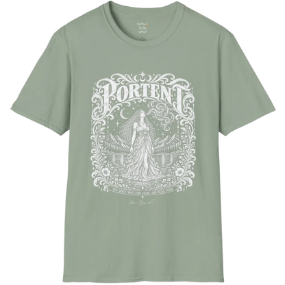 A short sleeved tee called the Portent T-Shirt, flat lay and a soft cotton shirt. Simply says, You don't wait for signs. You read them. Design highlights an ornate engraved frame of florals and filigree around a long-haired figure in a flowing gown standing before mountains and still water, with a crescent moon, stars and swirling smoke above and Portent in decorative lettering across the top. Color is Sage.