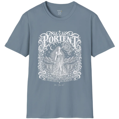 A short sleeved tee called the Portent T-Shirt, flat lay and a soft cotton shirt. Simply says, You don't wait for signs. You read them. Design highlights an ornate engraved frame of florals and filigree around a long-haired figure in a flowing gown standing before mountains and still water, with a crescent moon, stars and swirling smoke above and Portent in decorative lettering across the top. Color is Stone Blue.
