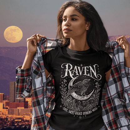 Black Raven T-Shirt lifestyle image featuring celestial raven artwork styled with relaxed boho streetwear energy and moonlit tones.