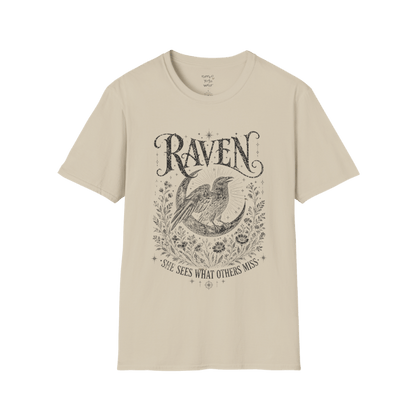 Sand Raven T-Shirt featuring spiritual raven artwork with botanical detailing, moon symbolism, and antique-inspired engraving textures.