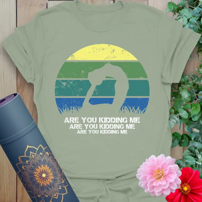 Calm sage green yoga t-shirt with retro playful yoga artwork and funny "Are You Kidding Me" quote for light-hearted mindful movement.