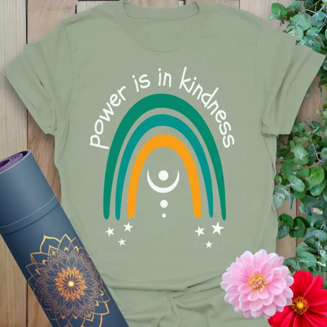 Calm sage green yoga t-shirt with colorful "Power is in Kindness" rainbow design symbolizing mindful strength and heart-led living.