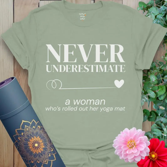 Sage Never Underestimate T-Shirt in calming tones. Empowering yoga message with minimalist heart and flowing line.