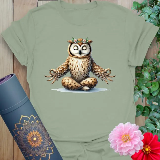 Calm sage green yoga t-shirt featuring wise owl in meditation pose, crowned with flowers for grounded mindfulness and joy.