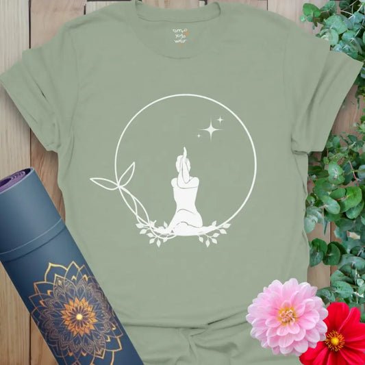 Sage green Solitude T-Shirt with white meditating silhouette in leafy circle with stars. Soft yoga tee for meditation and grounding.