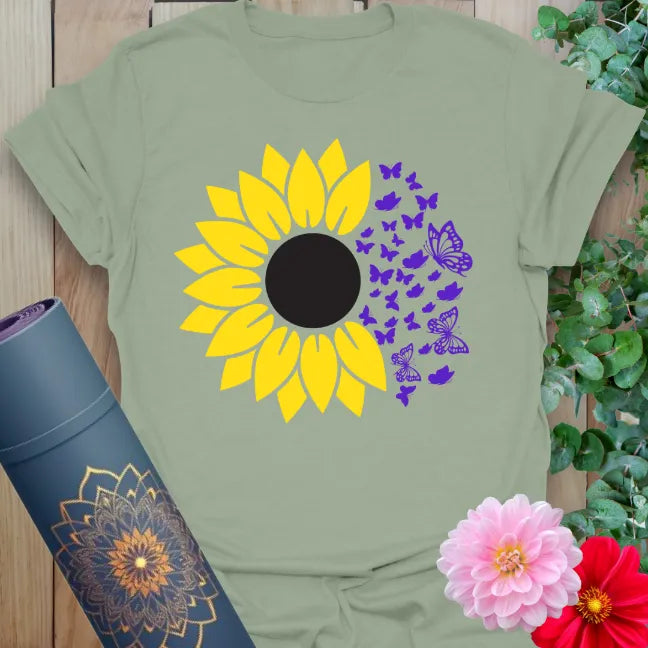 Sage green yoga tee with bright sunflower and butterfly design representing blooming, balance, and transformation.